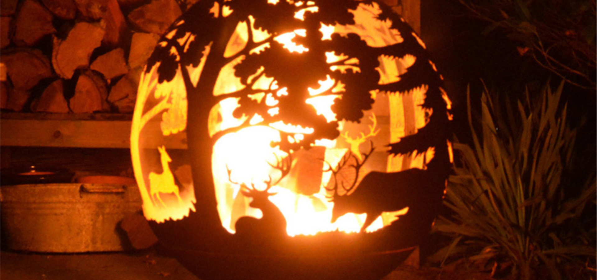 A lit Woodland Scene Fire Pit