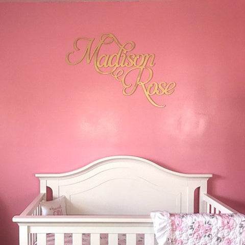 pink nursery wall with gold baby name sign