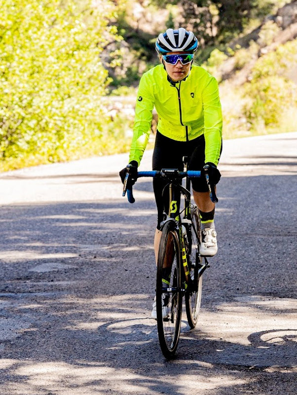 Woman cyclist wearing the Manic Yellow Divide Wind Jacket