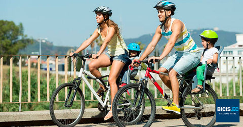 Familia feliz dando un paseo en bicicleta por la ciudad