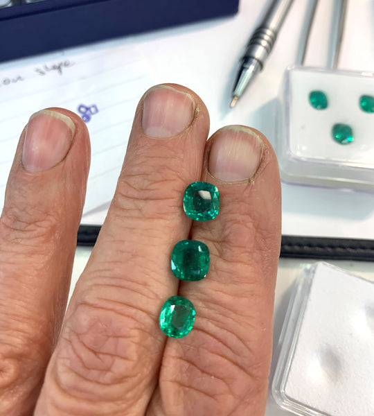 Three cushion cut emerald stones on Julia's hand