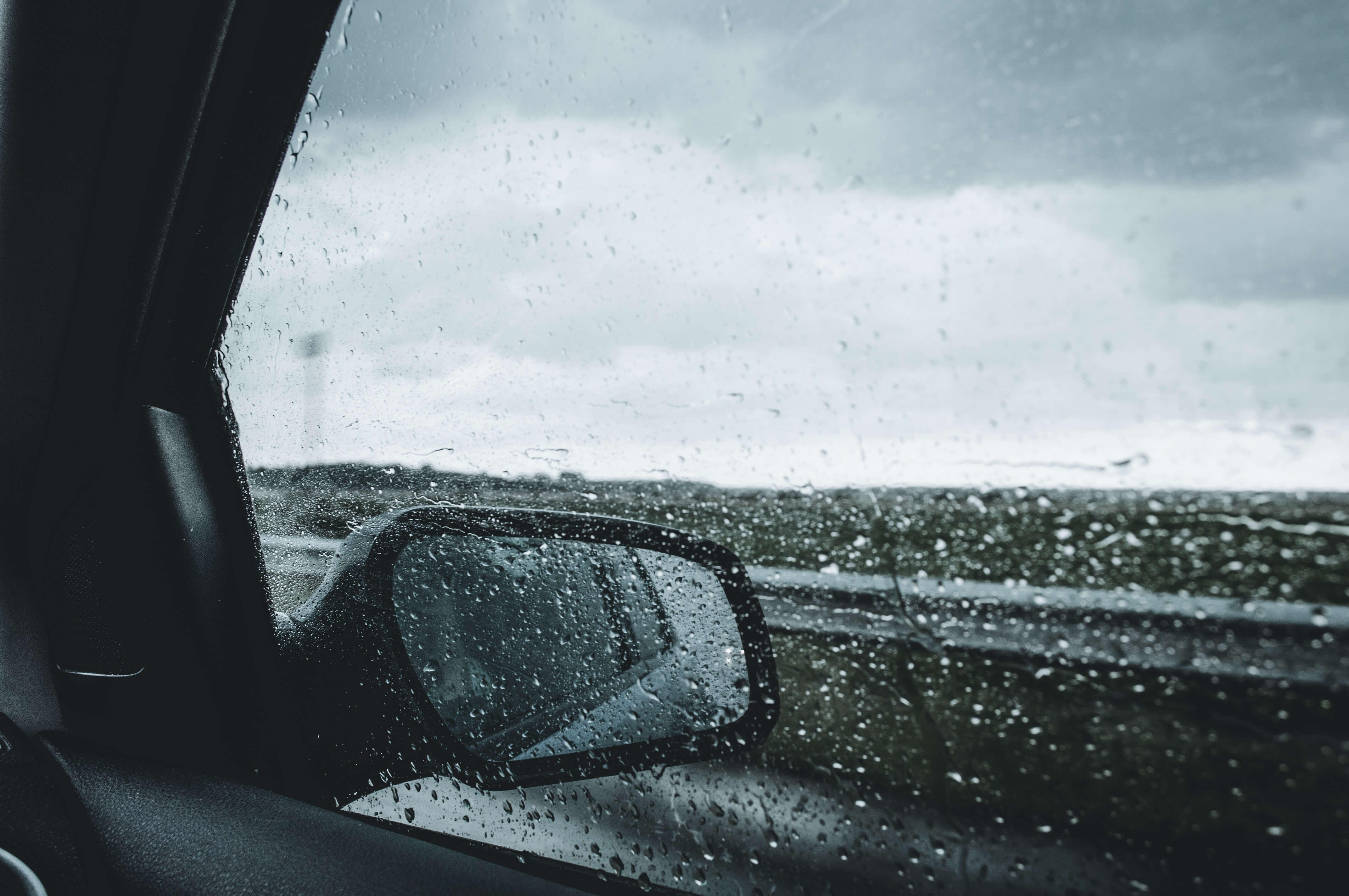 car wing mirror with rain on windows