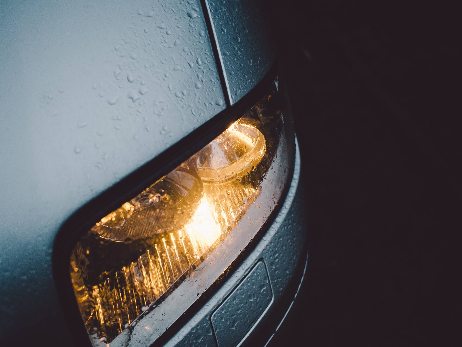 car headlight with yellow light and rain