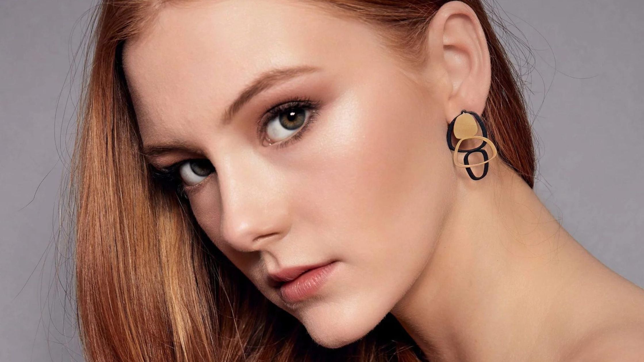 What are Stud Earrings - the image shows a woman wearing stud earrings