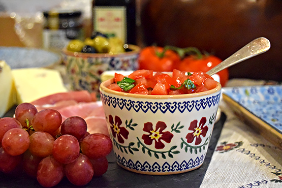 Nicholas Mosse Pottery Old Rose Custard Cup filled with chopped tomatoes on cheese board