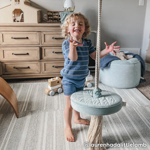 Rowan Birch neutral minimal stripe play mat shown in a childs bedroom with little boy laughing playing with a swing toy