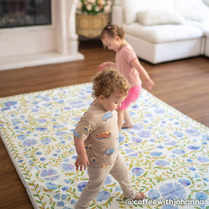 Suzette bluebell blue and green floral tumbling mat with 2 toddlers playing on the mat in a living room