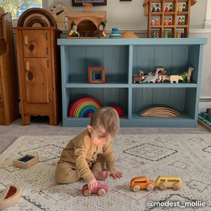 Neutral boho print baby play mat shown in play room with baby boy playing with toys. @modestmollie written in the bottom right hand corner.