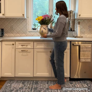 Ula indigo blue and white boho print standing mat, shown in kitchen with woman putting flowers in a vase standing on size 30x108