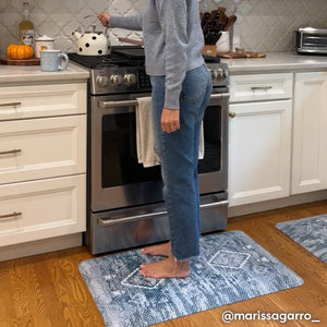 Ula indigo blue and white boho print standing mat, shown in kitchen with woman at the stove standing on size 22x36