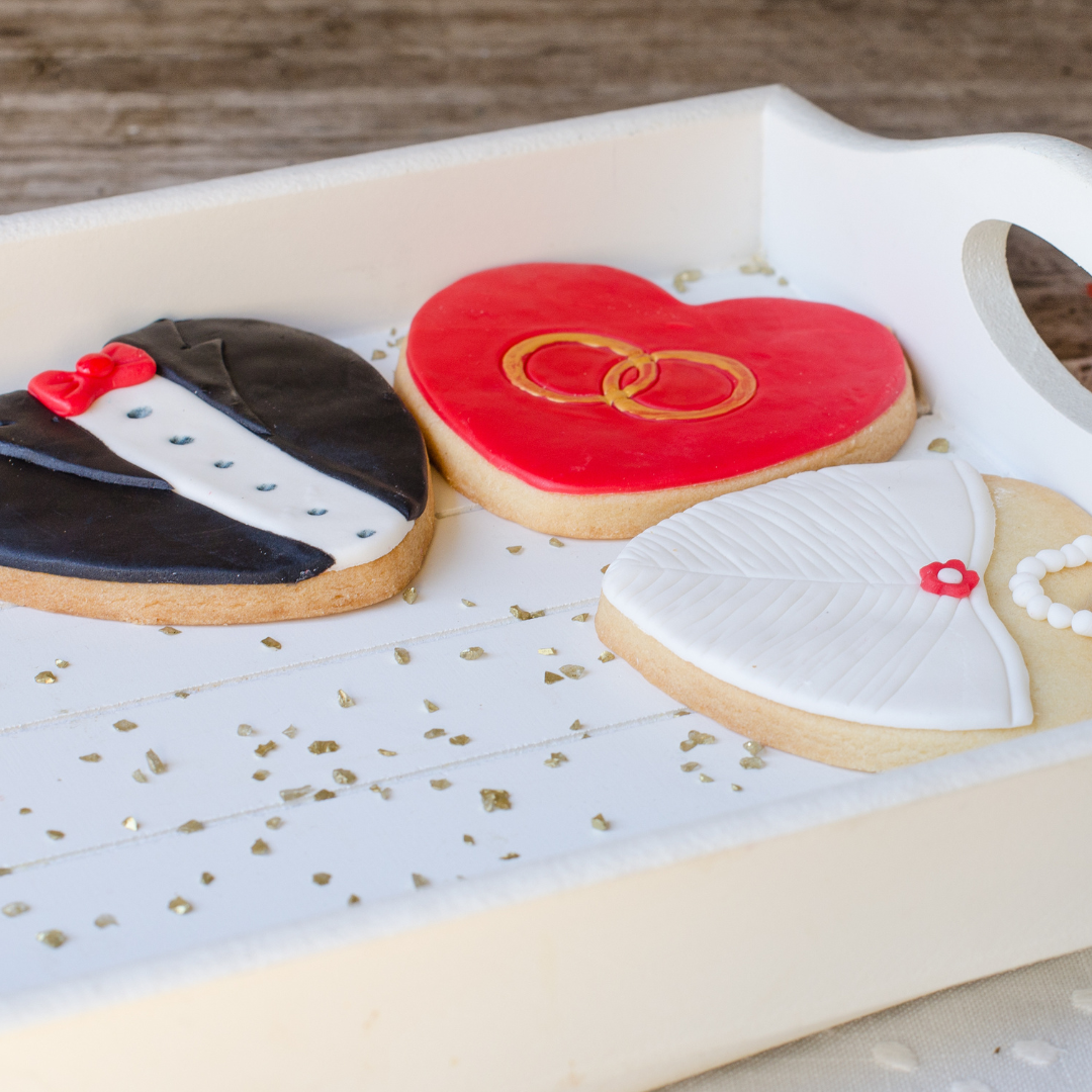 Heart-shaped cookies decorated like a wedding gown and groom tux