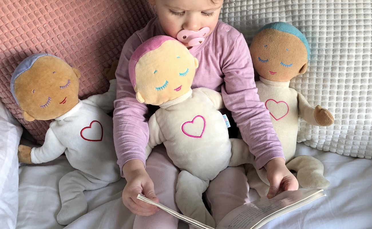 Girl reading with Lulla dolls