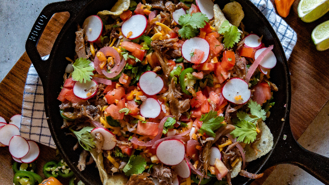 Duck confit nachos with roasted corn and tomatillo salsa.