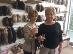 Jessica's Wig and Beauty Salon, Pink Ribbon Breakfast, photo of guests with wigs in the background