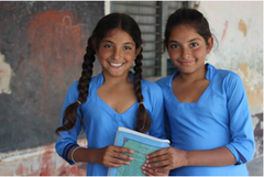 Two girls holding a text book