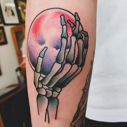 hand holding crystal ball tattoo