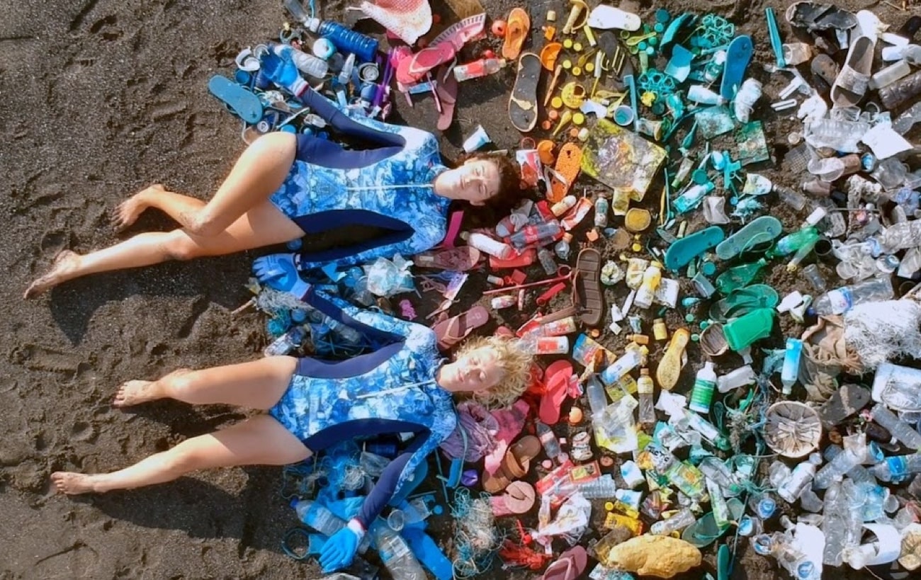 ladies laying on trash collected from the ocean used to make oceanmimic swimwear
