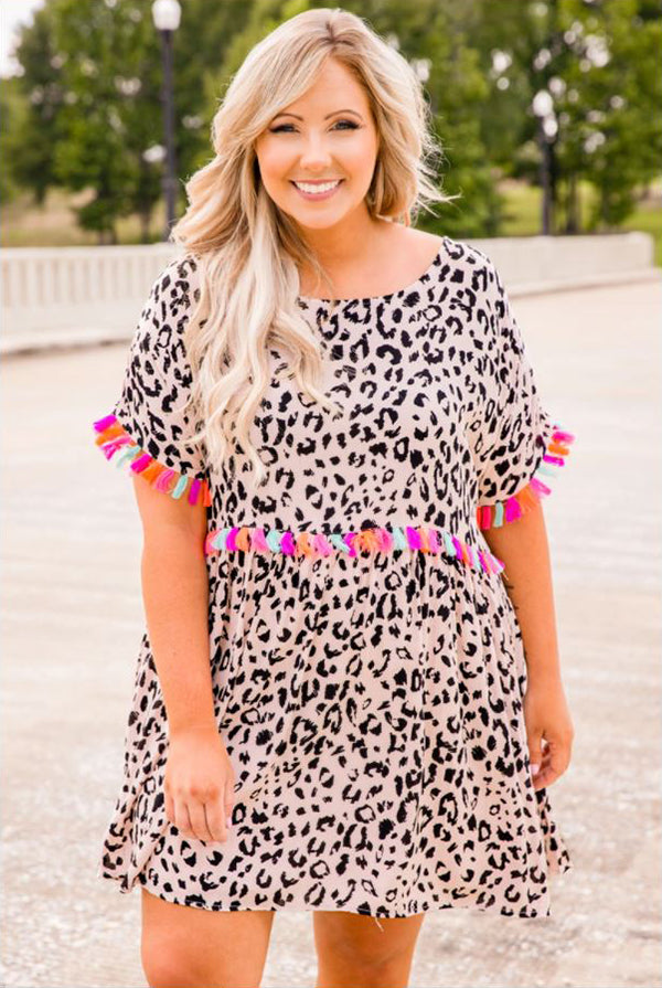 a smiling woman wearing a stepping ahead dress in leopard print