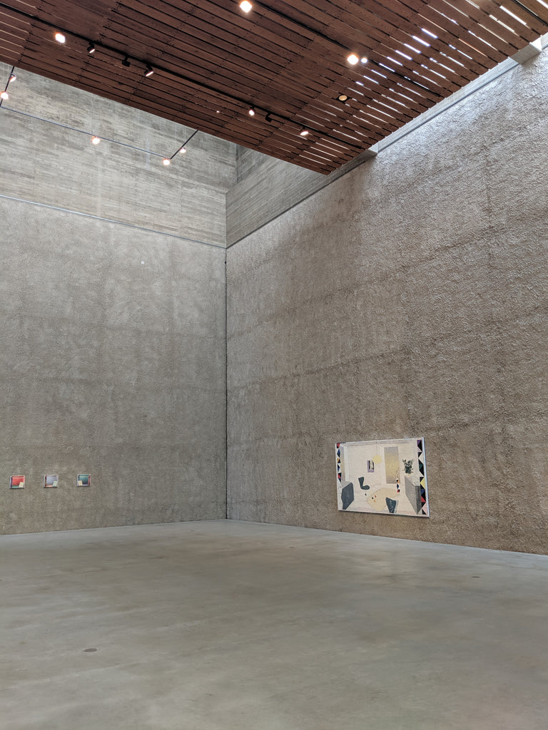 An empty room with a concrete wall and wooden ceiling