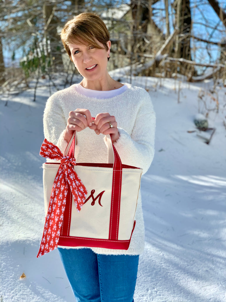 Laura holding L.L. Bean Boat and Tote bag with The Maine Square lobster print retro ribbon tied on it