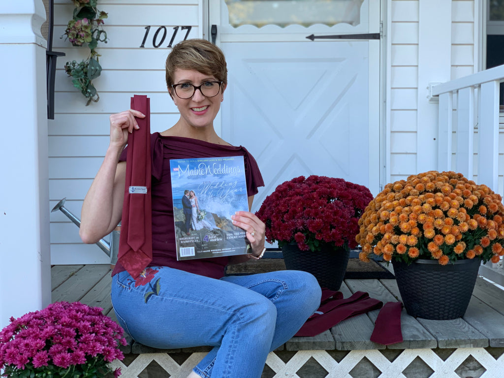 Laura Michaud holding necktie she designed for Real Maine Weddings Wedding of the year 2019