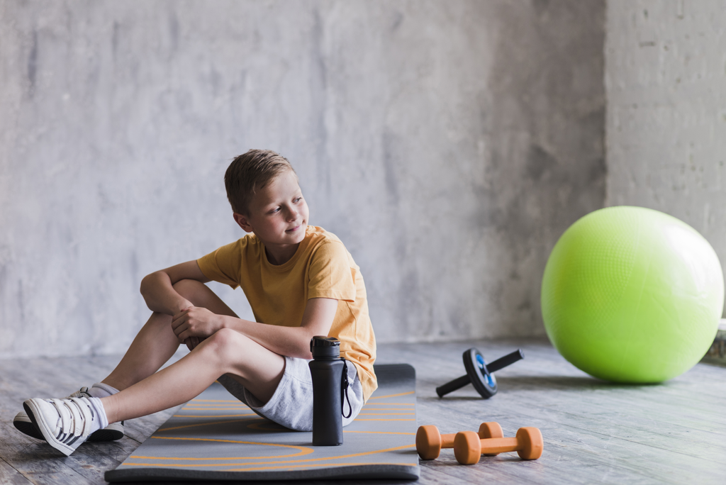 Boy with weights on exercise mat