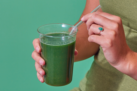 Woman Holding Laird Superfood Prebiotic Daily Greens Drink in Glass