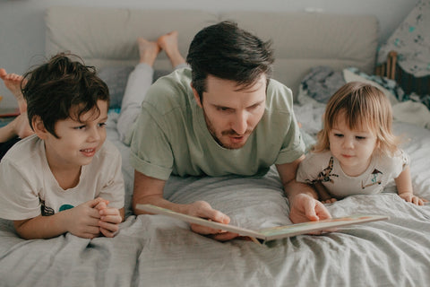 Bearded man reading to his children
