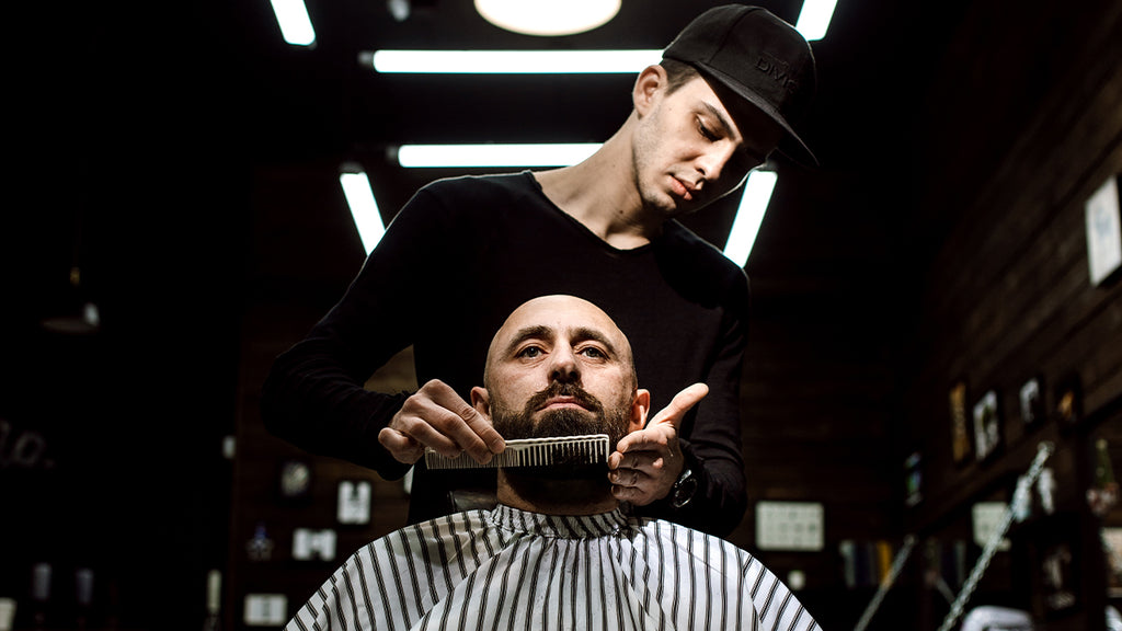 Man getting beard groomed in barber chair