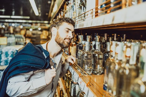 Bearded man looking at alcohol on a shelf