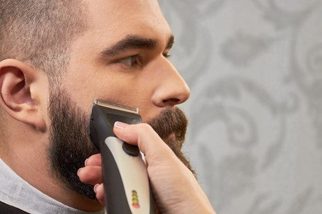Man getting a trim to control maintain his growing beard