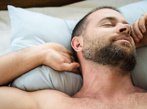 Man with beard laying in bed