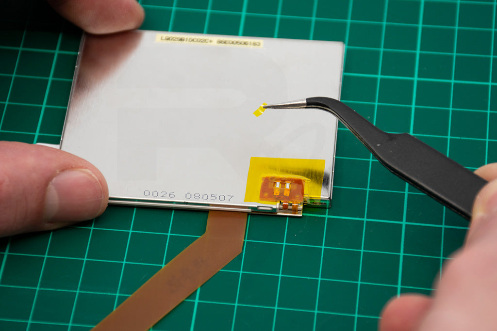 Carefully carve a hole on the topmost tape to reveal the solder pads from the top ribbon.