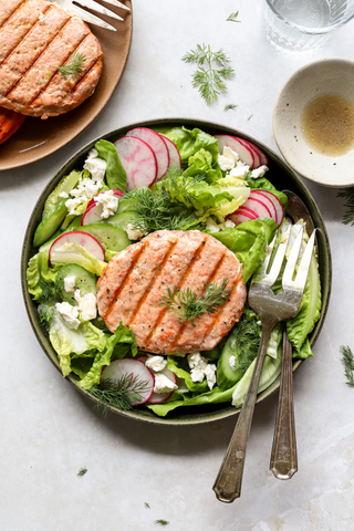 Salmo burger on top of a green salad