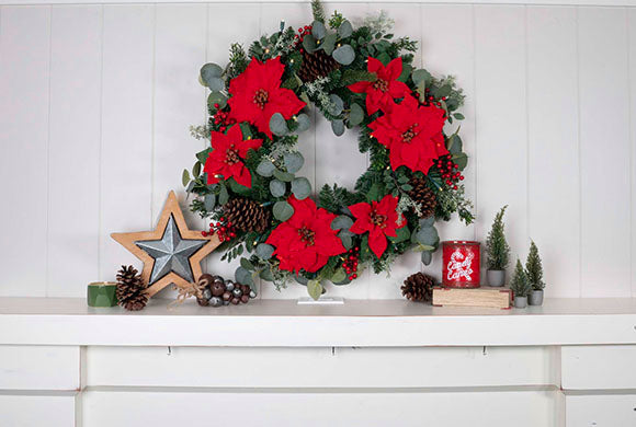 Christmas Poinsettia Wreath and Garland Hanging Above Fireplace Mantle