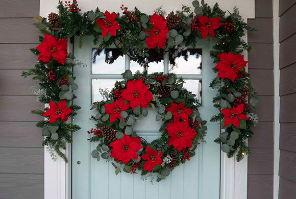 Christmas Poinsettia Wreath and Garland Hanging On Front Door