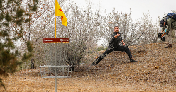 A disc golf player throws a disc