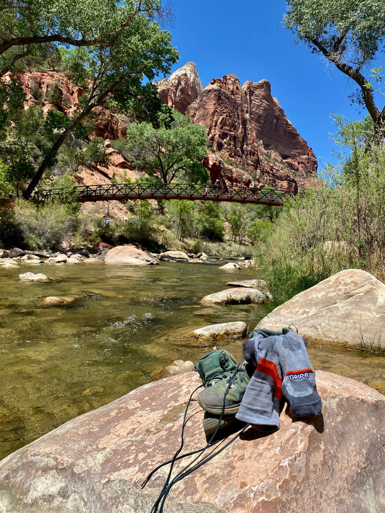 GRIP6 socks are designed for all times of the year. Pictured is a pair of socks with hiking boots on a rock in Zion National Park.