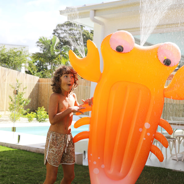 Child watching the Sonny The Sea Creature Orange Sprinkler in action