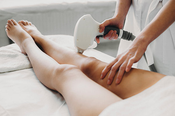 Cosmetologist doing laser epilation to her client. 