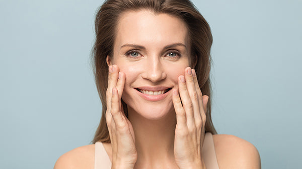 Smiling woman touch healthy skin.