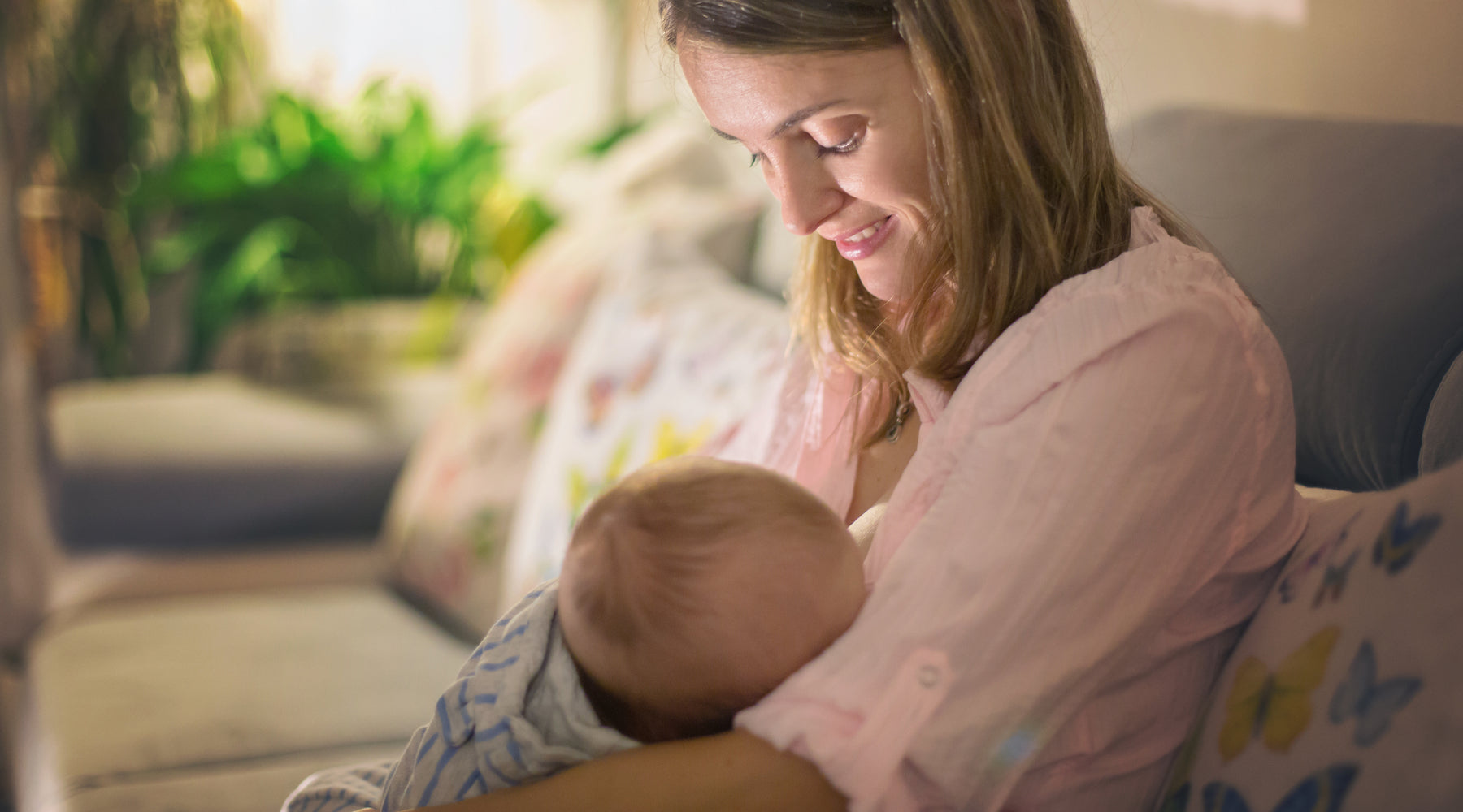 woman smiling and looking down at her baby