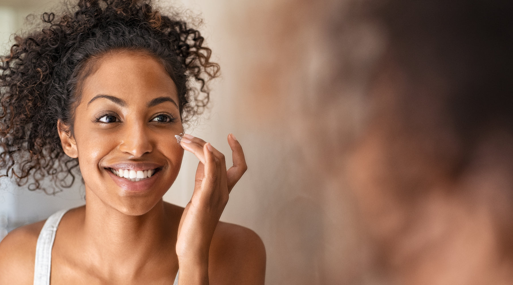 woman applying skincare to her face