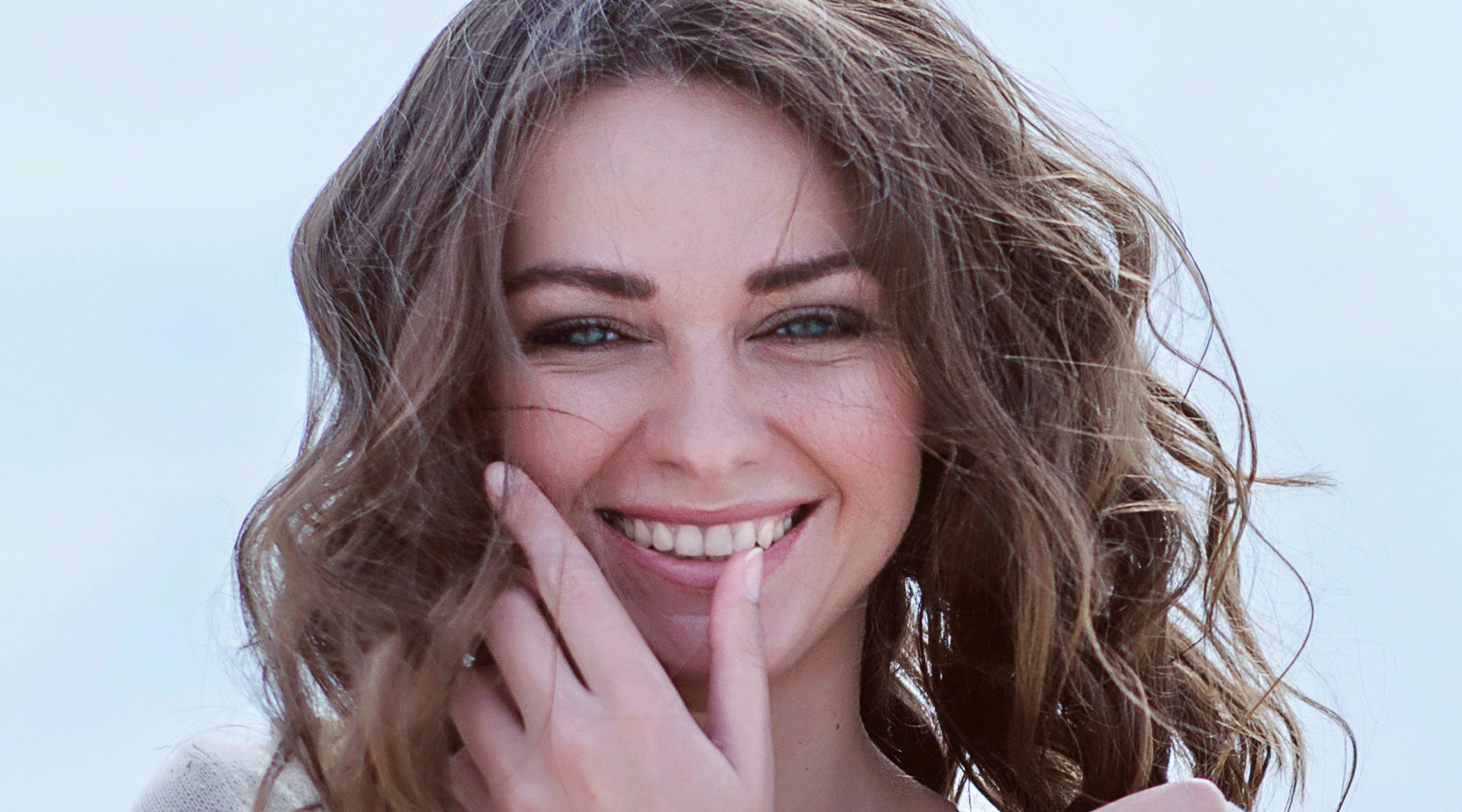 Smiling woman with hand touching face