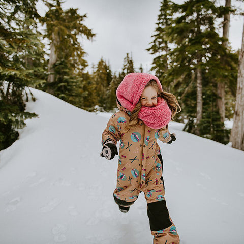 Girl Running and Wearing One-Piece Snowsuit in Beige