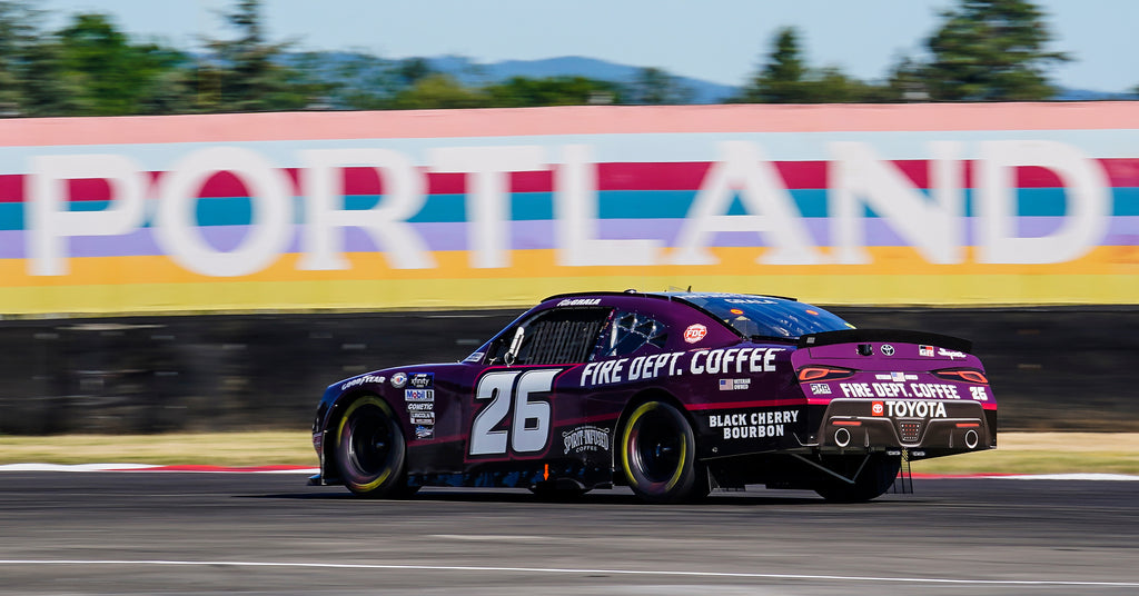 Black Cherry Bourbon race car with sign that reads Portland in the background.