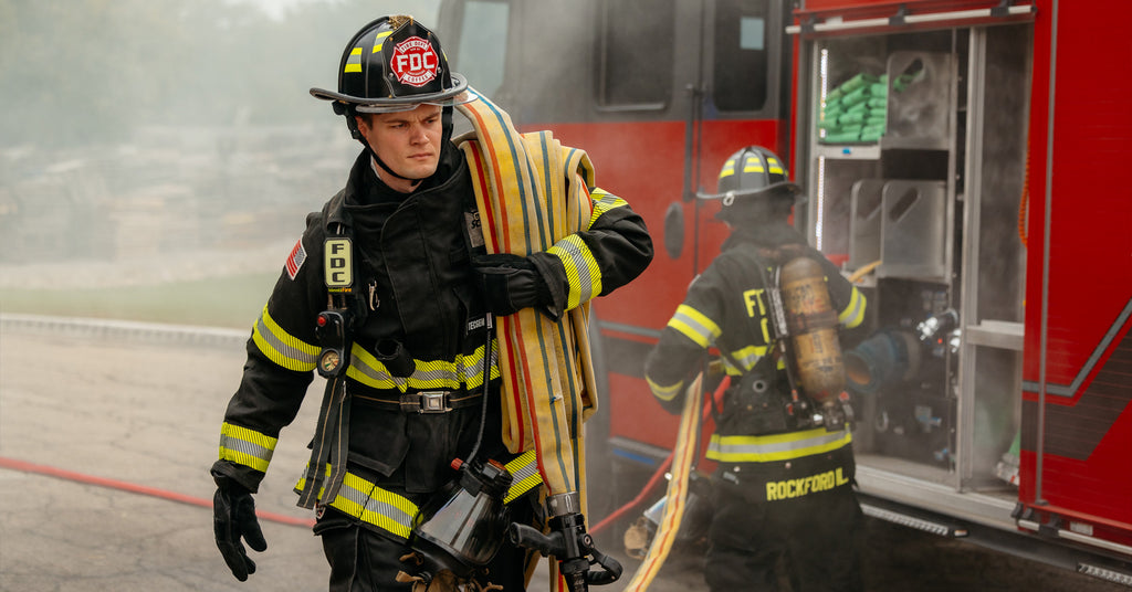 Firefighter Josh Kennedy pulling a hose from a fire truck.