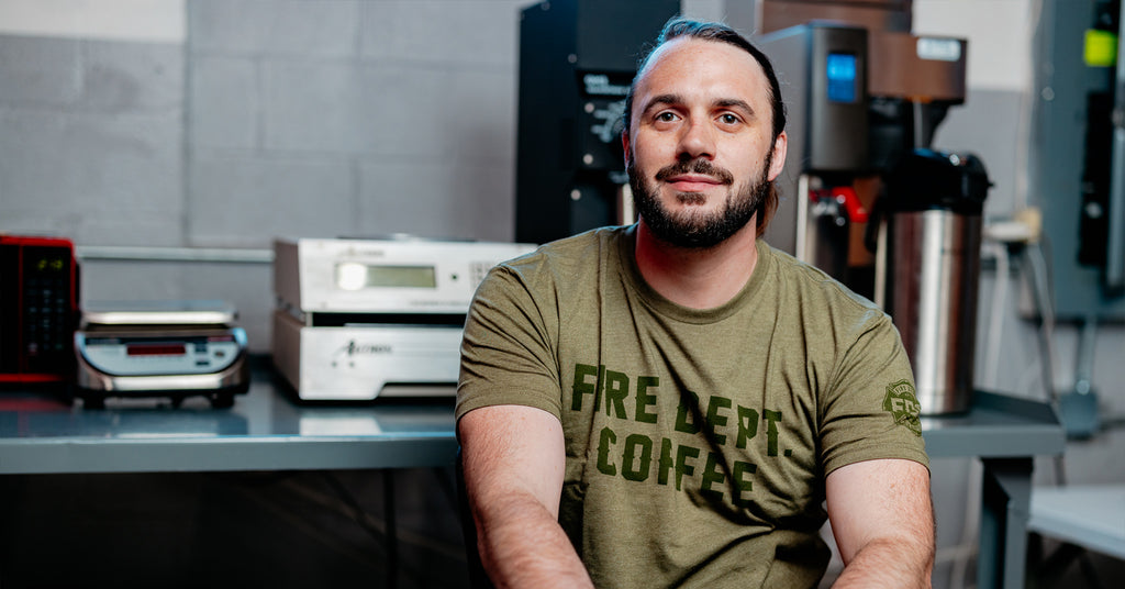 Jacob Ball sitting inside the Fire Dept. Coffee roastery, looking at the camera.