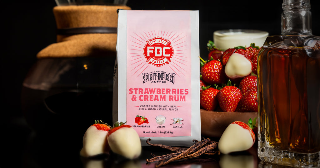 Fire Dept. Coffee's bag of Strawberries and Cream Rum infused coffee flanked by a bowl of strawberries and a Chemex coffee maker.