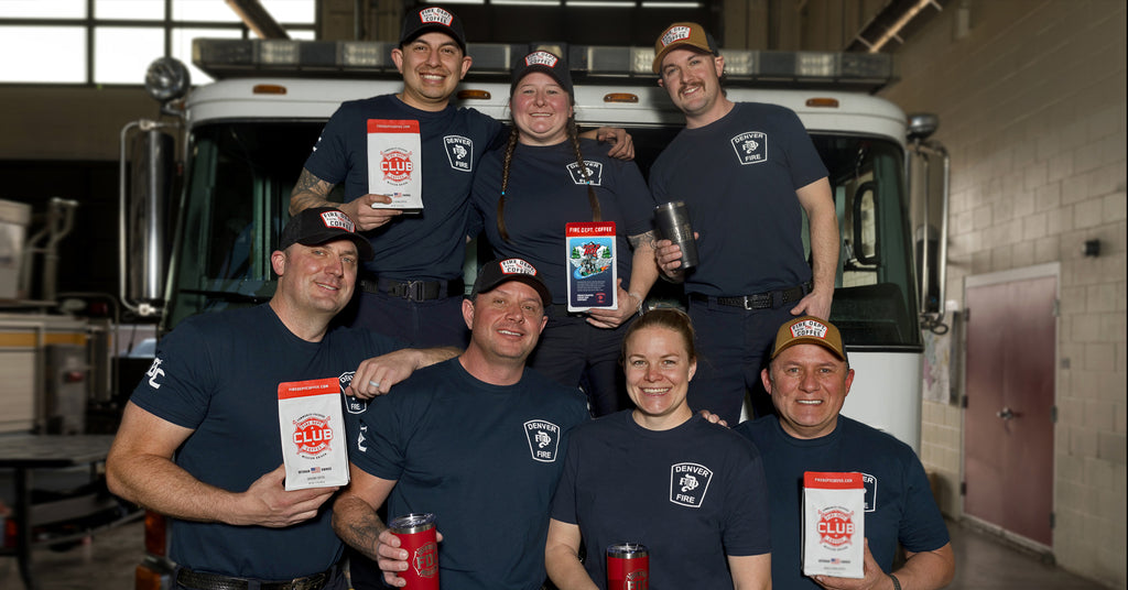 Group of Denver firefighters standing together in front of a fire truck.